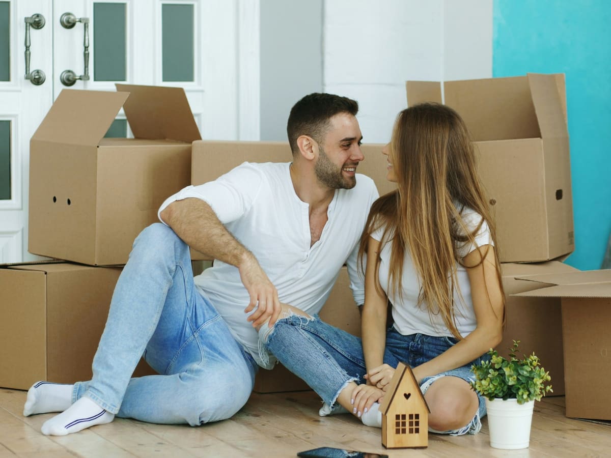 Couple surrounded by moving boxes in new home