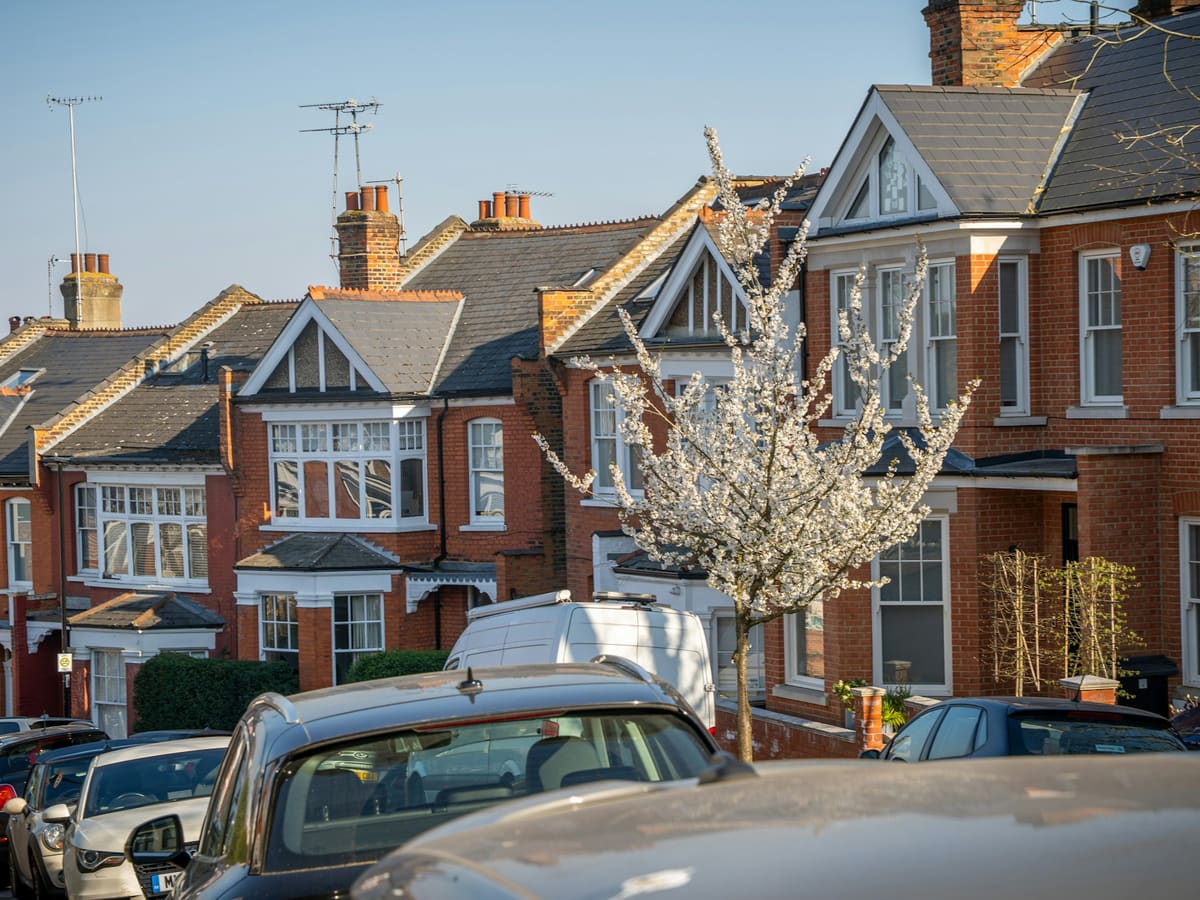 Row of brick houses with parked cars on street