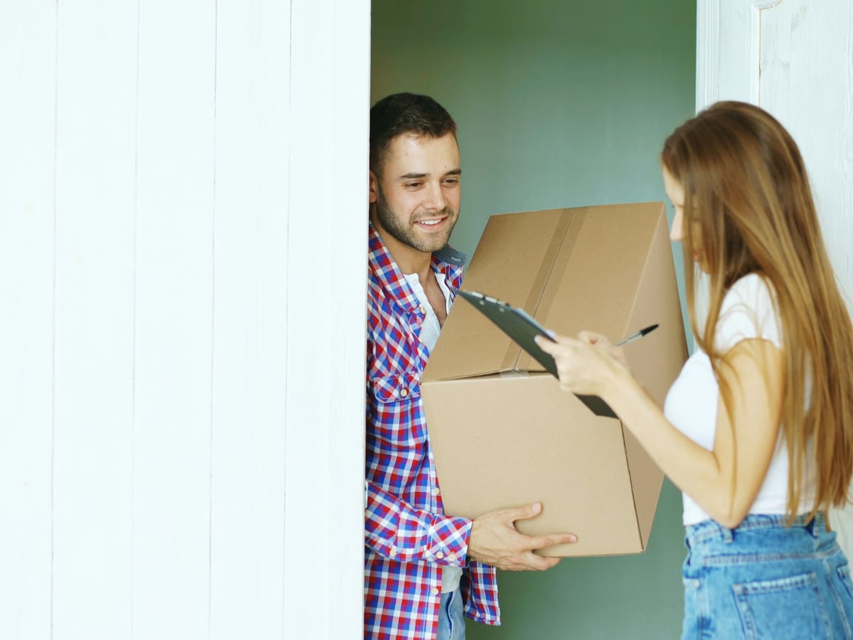 Couple signing for a package delivery at the door